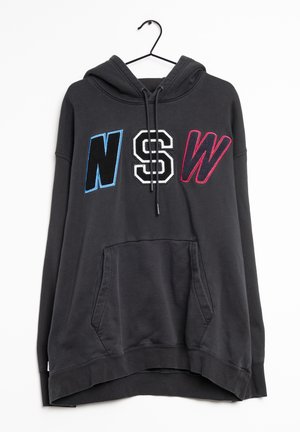 Schwarzer Kapuzenpullover mit den Buchstaben "NSW" in Blau, Weiß und Rot auf der Brust und einer Kängurutasche vorne, hängend an einem schwarzen Kleiderbügel.