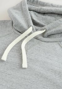 Hanorac gri dintr-un amestec de bumbac, având un sistem de închidere cu șnururi de culoare crem și o textură moale, plăcută la atingere.