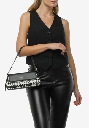 Débardeur noir associé à un pantalon en cuir noir ajusté. Le sac est de forme rectangulaire avec un motif pied-de-poule noir et blanc, doté d'une sangle élégante.