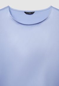 Blusa a maniche corte di colore lilla chiaro con una texture liscia e lucida; presenta uno scollo rotondo e un'etichetta con la scritta "CALLIOPE" e la misura "S".