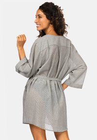 Szary, paskowany szlafrok z paskiem w talii, rękawami 3/4 i luźnym krojem. Lekkie materiał o miękkiej teksturze.
