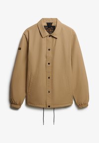 Beige werkkledingjack met een kraag, twee zijzakken, drukknopen sluiting, elastische manchetten en een verstelbare onderkant.