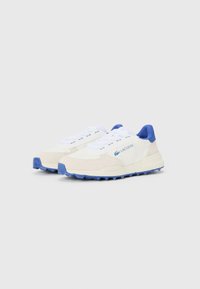 Lacoste sneakers feature a white fabric body with cream suede accents and blue rubber sole. Flat laces and branded logo on the side.