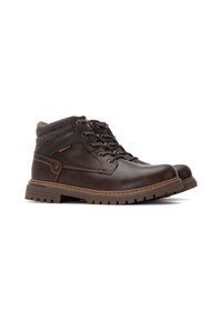 Botas de cuero marrón con un collar de tejido gris texturizado, diseño de cordones, lengüeta acolchada y suela de goma resistente. Los acentos incluyen contornos y costuras.