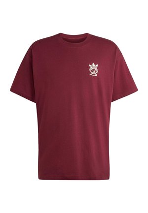 Bordeauxrotes T-Shirt mit kurzen Ärmeln und kleinem weißem grafischem Logo mit einer stilisierten Figur und dreiblättrigem Emblem auf der linken Brust.