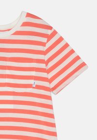 T-shirt à manches courtes avec des rayures horizontales alternées corail et blanches, une poche poitrine et une étiquette sur l'ourlet. Matière en coton.