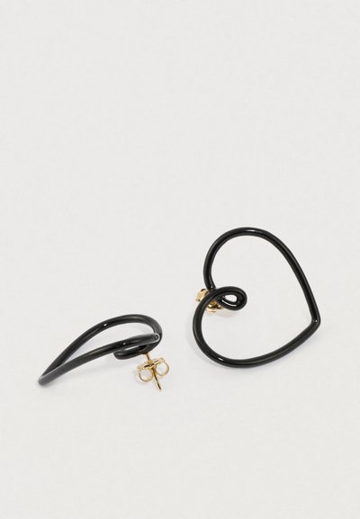 Juodos spalvos metaliniai auskarai širdies ir spiralės formomis, su auksinio tono akcentais. Glotnios tekstūros su blizgiu paviršiumi.
