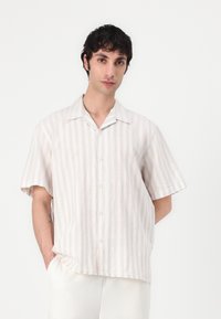 Κοντομάνικο πουκάμισο με κουμπιά. Κατασκευασμένο από ελαφρύ ύφασμα με στενές κάθετες ρίγες σε μπεζ και κρέμα. Κλασικό γιακάς, χαλαρή εφαρμογή.