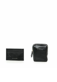 Portafoglio in pelle nera e pochette con zip, entrambi caratterizzati da una finitura rugosa. Marchio dorato sul fronte. Forme compatte e rettangolari.