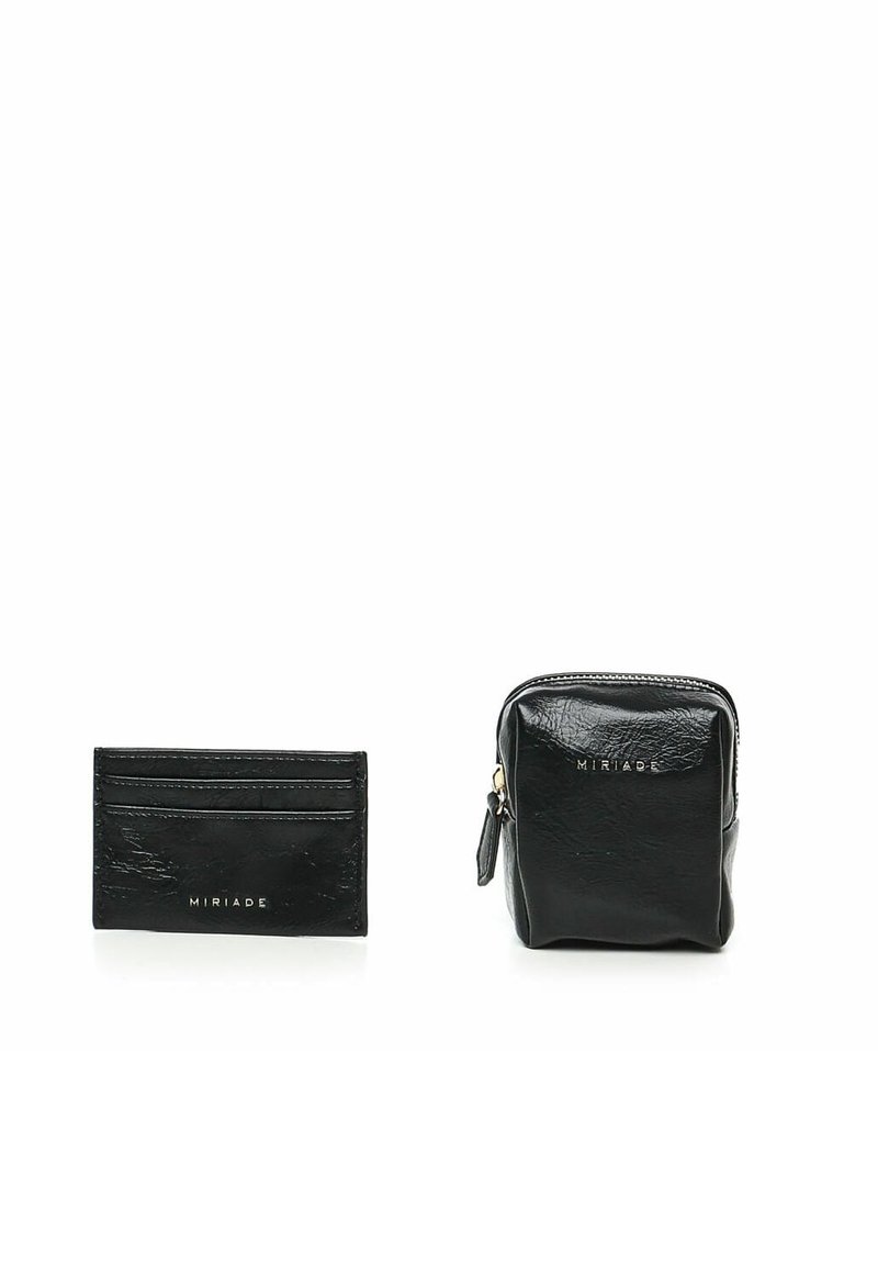 Portafoglio in pelle nera e pochette con zip, entrambi caratterizzati da una finitura rugosa. Marchio dorato sul fronte. Forme compatte e rettangolari.