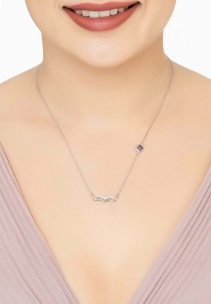 Silver necklace featuring a wavy design with small, round accents. Includes a purple gemstone attached to a delicate chain.