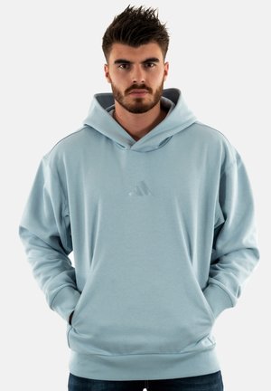Sudadera con capucha de color azul claro, con dobladillo y puños acanalados, que presenta un pequeño logotipo en relieve en el pecho. Fabricada con una suave tela texturizada.
