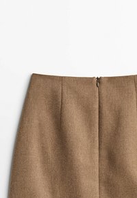 Jupe en textile brun à texture lisse, avec une fermeture éclair centrée au dos et des plis subtils près de la taille pour une mise en forme.