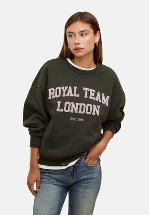 Felpa verde scuro con la scritta "ROYAL TEAM LONDON EST. 1965" in lettere rosa. Realizzata in tessuto morbido, ha una vestibilità comoda e polsini a coste.