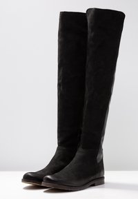 Botas de hasta la rodilla en negro con un superior de ante suave y detalles de cuero elegante. Presentan una puntera redondeada y una cremallera lateral para facilitar su uso.