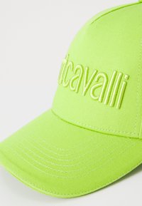 Neon green baseball cap with a structured design, featuring embroidered logo on the front and distinct texture of fabric.