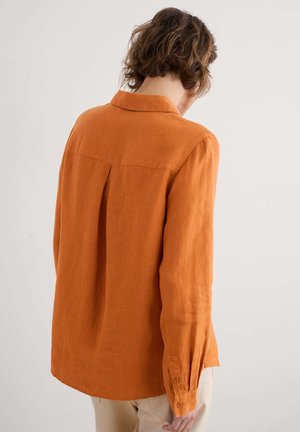 Koperkleurig linnen shirt met een kraag, lange mouwen en een plooidetail aan de achterkant, met een ontspannen pasvorm en een textuurstof.