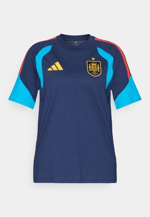 Tmavě modrý sportovní dres se světle modrými akcenty, červeně pruhovanými rameny a žlutým logem Adidas. Na hrudi se nachází znak národního týmu Španělska.