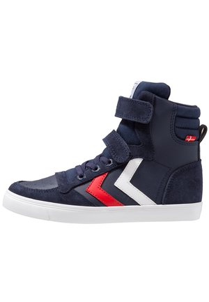 Baskets montantes de couleur bleu marine en matières suédées et synthétiques. Elles présentent des accents en chevrons rouges et blancs, des lacets et des systèmes de fermeture Velcro, ainsi qu'une semelle blanche.