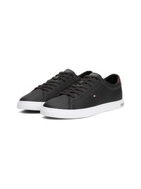 Schwarze Sneakers aus synthetischem Leder mit weißen Gummisohlen, runder Zehenpartie und schwarzen Schnürsenkeln; mit kleinem farbigen Logo an der Seite.