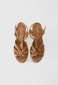 Sandali platform in pelle marrone con design a strappo intrecciato e chiusura con fibbia alla caviglia, caratterizzati da una texture liscia e punta aperta.