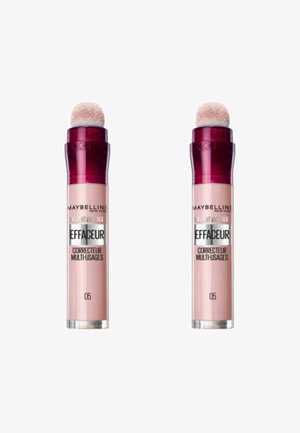 Deux correcteurs Maybelline Instant Anti-Age, présentant un tube rose avec un embout en éponge arrondi, un capuchon bordeaux et une étiquette en texte argenté.