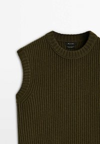 Veste sans manches en maille côtelée vert olive foncé avec un col rond et une étiquette en tissu à l'intérieur du col.