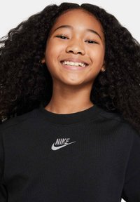 Felpa nera con collo rotondo e polsini a coste, con il logo Nike bianco ricamato sul petto.