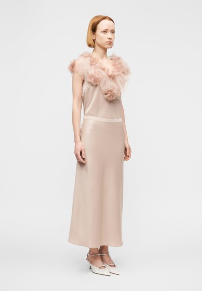 Μακρύ, διάφανο φόρεμα σε ανοιχτό μπεζ απόχρωση με βολάν στο λαιμό από τούλι. Λείο ύφασμα με εφαρμοστό στη μέση και μήκος μέχρι τους αστραγάλους. Απλός, κομψός σχεδιασμός.