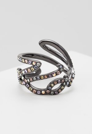 Czarna metalowa nauszka z falistym, otwartym wzorem ozdobiona małymi, wielokolorowymi cyrkoniami na białej powierzchni.