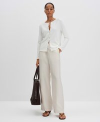Weißer, langärmeliger Cardigan mit rundem Ausschnitt und Knopfverschluss, kombiniert mit hellbeigen weiten Hosen und einer dunkelbraunen Tote-Tasche.