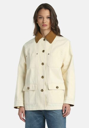 Kremfarvet lærredsjakke med en brun krave, knappelukning foran, to brystlommer og to nederste lommer, udstyret med guldfarvede beslag.