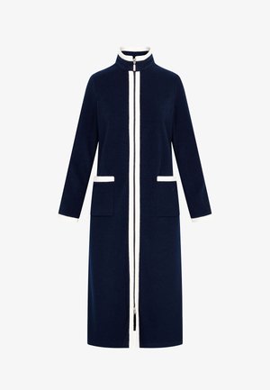 Marineblauer langer Mantel mit hochstehendem Kragen, weißem Reißverschluss und zwei Fronttaschen. Mit weißen Akzenten entlang der Kanten und vertikalen Streifen.