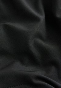 Black fabric with a smooth, matte texture, displaying subtle wrinkles and folds, emphasizing a lightweight and flexible material.
