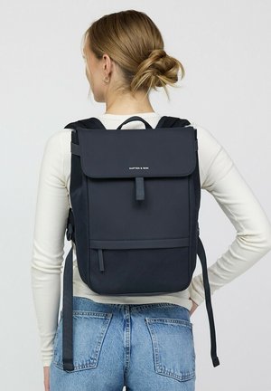 Navy backpack with a flap closure, adjustable straps, and a front pocket. Made from durable material, features an embossed logo on the front.