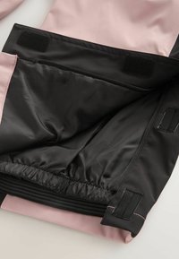 Rožinė ir juoda striukės vidus, turintis lygų juodą pamušalą, elastingą juosmenį, užtrauktuko kišenę ir Velcro akcentus saugiam uždarymui.