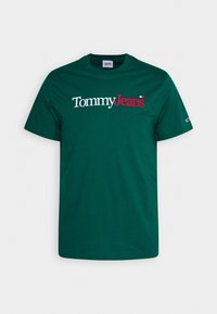 Camiseta de algodón verde oscuro con un destacado logo en blanco y rojo de "Tommy Jeans" en el pecho, con un clásico cuello redondo.