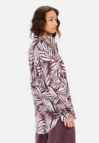 Langarmshirt in donker bordeauxrood met wit loofmotief, met een knoopsluiting kraag en manchetten, gemaakt van lichte stof.