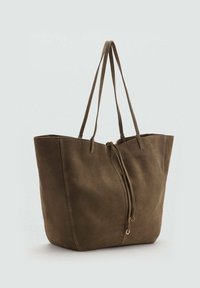 Sac fourre-tout vert olive en daim doux avec deux longues poignées, une fermeture à cordon, et des accents matériels minimaux. Détails de couture verticale.