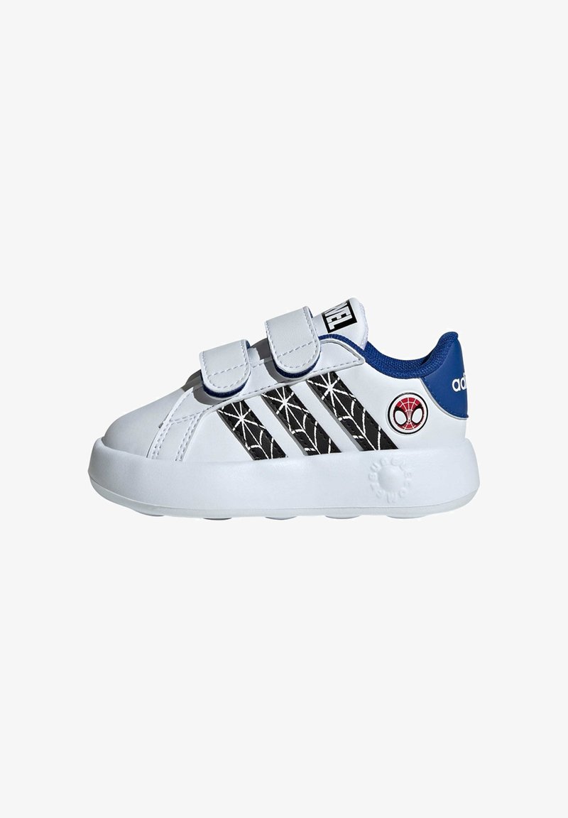 White sneaker with black spider web design, blue accents on the heel, twin Velcro straps, and textured rubber sole. Red Spider-Man logo on the side.