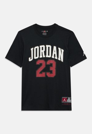 Juoda medvilninė marškinėliai su užrašu „JORDAN“ baltai ir skaičiumi „23“ raudonai priekyje. Apačioje kairėje pusėje yra logotipo žymė. Trumpomis rankovėmis.