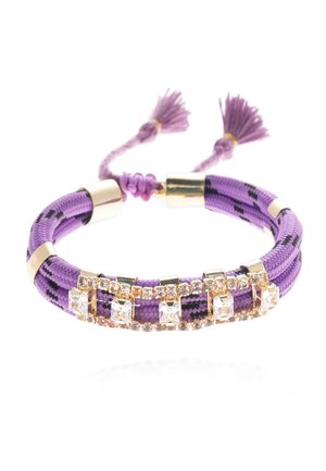 Bracelet tressé violet avec accents dorés et cristaux clairs. Fini avec des pompons décoratifs à chaque extrémité. Matériau texturé.