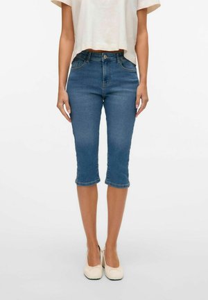 Blå denim capri jeans med en tætsiddende design, mellemhøj talje og korte ben, der har forlommer og en glat overflade.