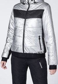 Silver puffjacka med svarta detaljer, dragkedjestängning och huva. Har elastiska muddar och logotyp på fållen. Slim fit-design.