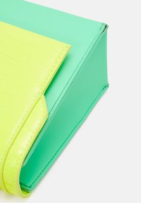 Two boxes in vibrant colors: one in textured neon yellow with a crocodile pattern, the other in smooth mint green with sharp edges.
