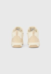 Μπεζ αθλητικά παπούτσια με λείο σύνθετο επάνω μέρος, αντίθετο τακούνι από σουέτ και επενδυμένο γιακά. Διαθέτουν φερμουάρ στο πίσω μέρος για εύκολη πρόσβαση.