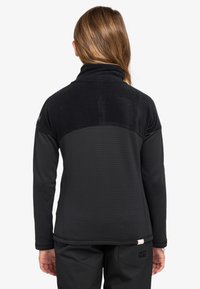 Czarna polarowa kurtka z textured górną częścią w kratkę i gładką dolną częścią, wysokim kołnierzem oraz subtelnym brandingiem na rękawie.