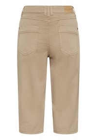 Beiget värilliset lyhennetyt housut suorilla lahkeilla, joissa on kaksi takataskua ja nahkainen merkki vyötärökaitaleessa. Sileä kangaspinta ja minimaalinen ompelu.