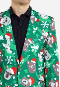 Žalias švarkas su animacinėmis lamomis ir snaigėmis, su šventiniu Santa hat raštu. Dvigubo mygtuko užsegimas ir išpjovos apykaklė.