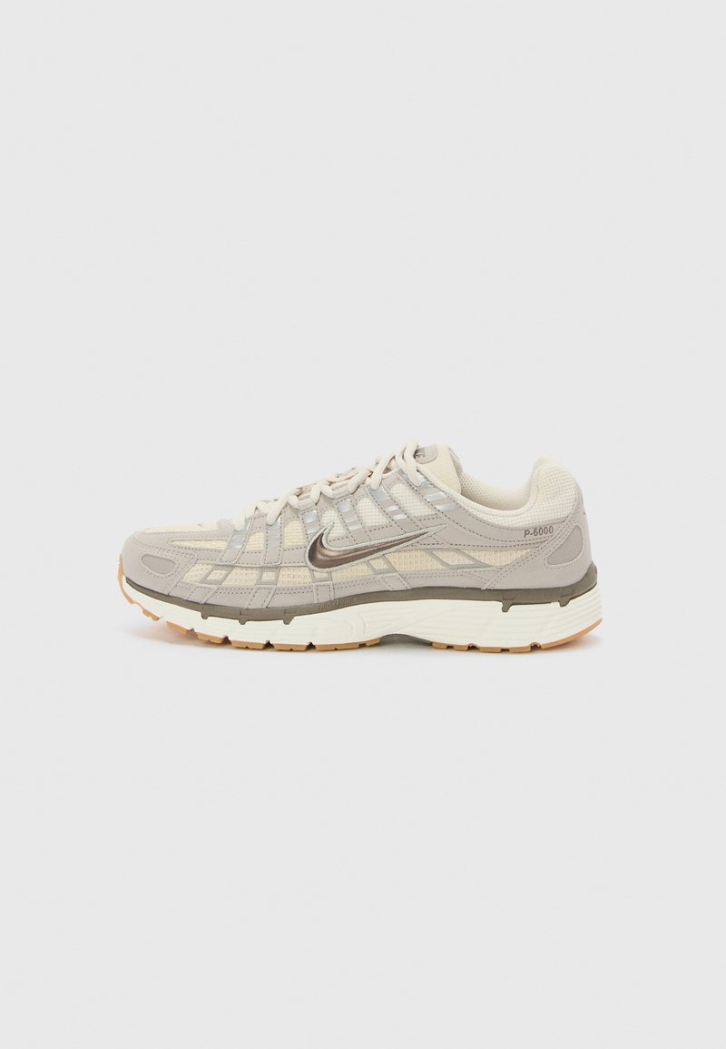Beige ja harmaa urheilukenkä, jossa on verkkoberus, heijastavat yksityiskohdat, teksturoidut pinnat ja kumipohja pitoa varten. Malli P-6000.